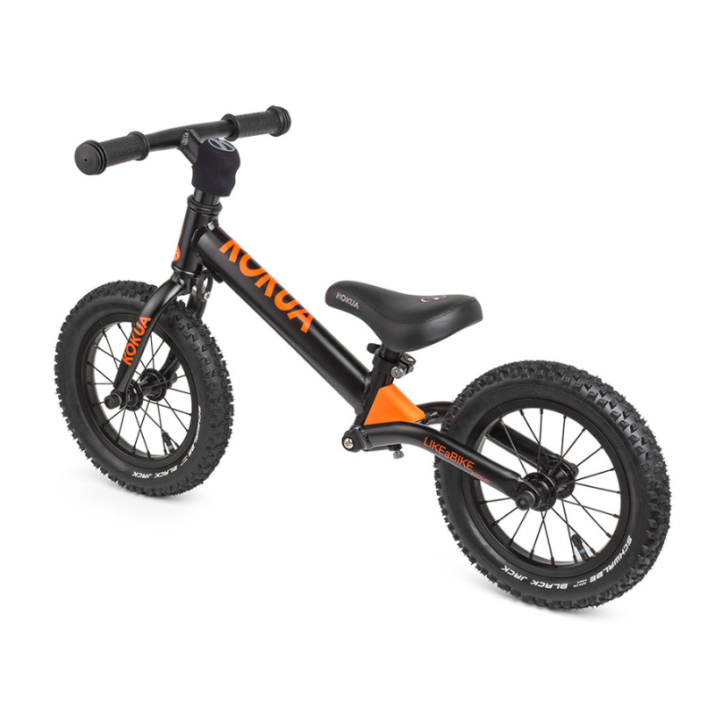 a black and orange KOKUA Jumper 12 balance bike on a white background