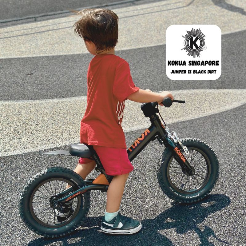 a young boy riding a KOKUA Jumper 12 balance bike