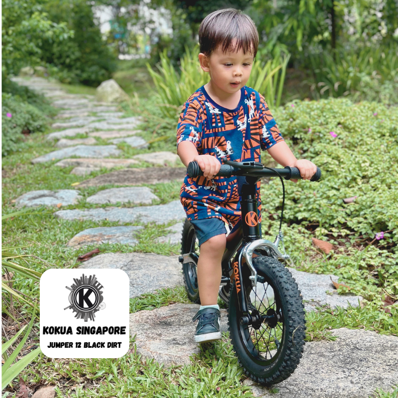 a young boy riding a KOKUA Jumper 12 balance bike on a path