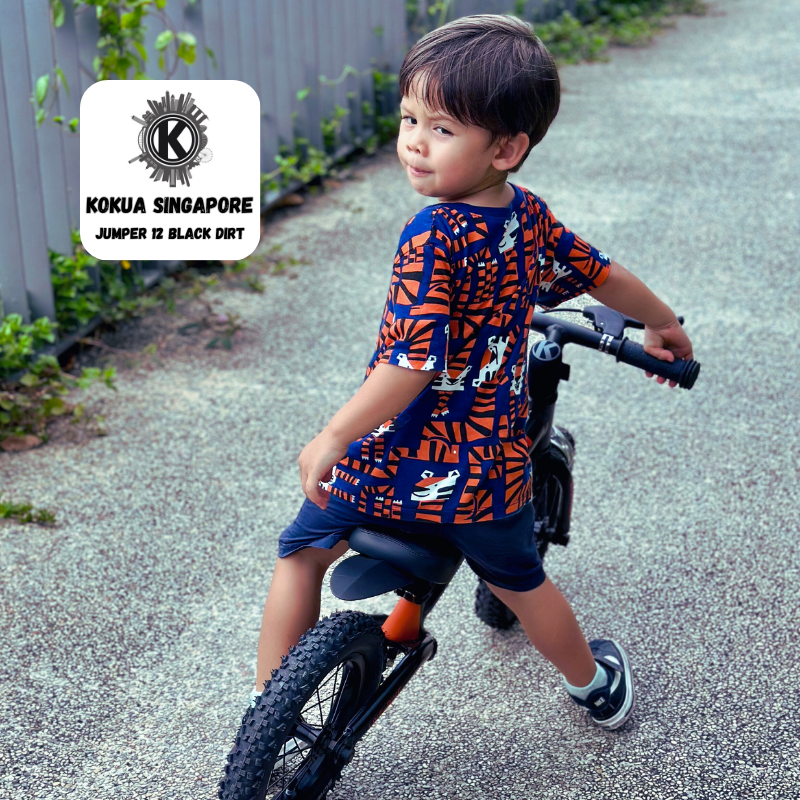 a young boy riding aKOKUA Jumper 12 balance bike on a gravel road