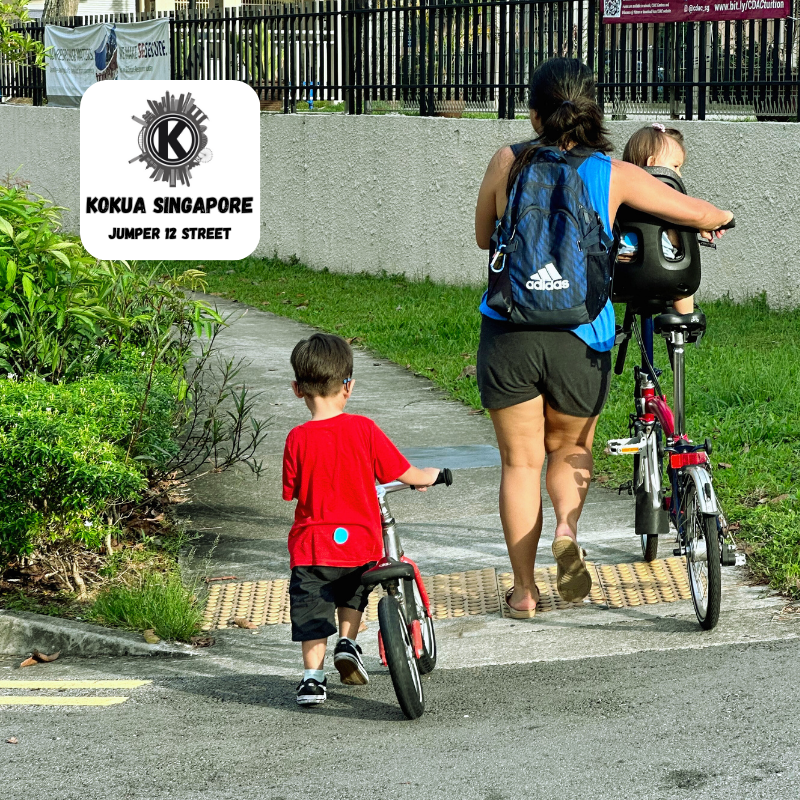 a woman and a boy are walking with their KOKUA Jumper 12 balance bikes