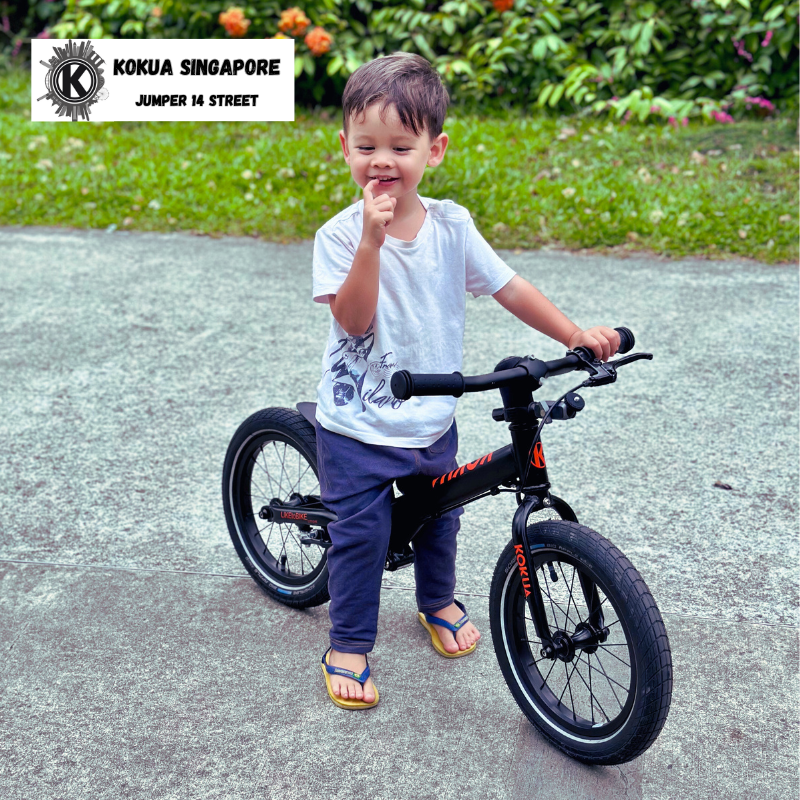 a young boy sitting riding a KOKUA Jumper 14 balance