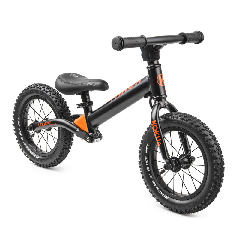 a black and orange KOKUA Jumper 12 balance bike on a white background