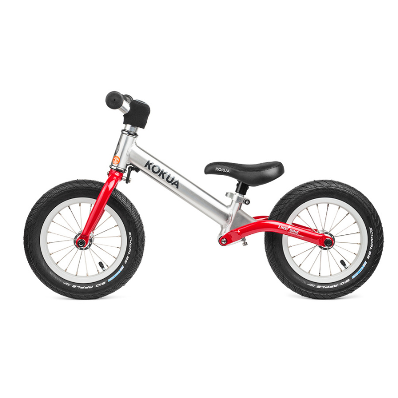 a red and silver KOKUA Jumper 12 balance bike on a white background