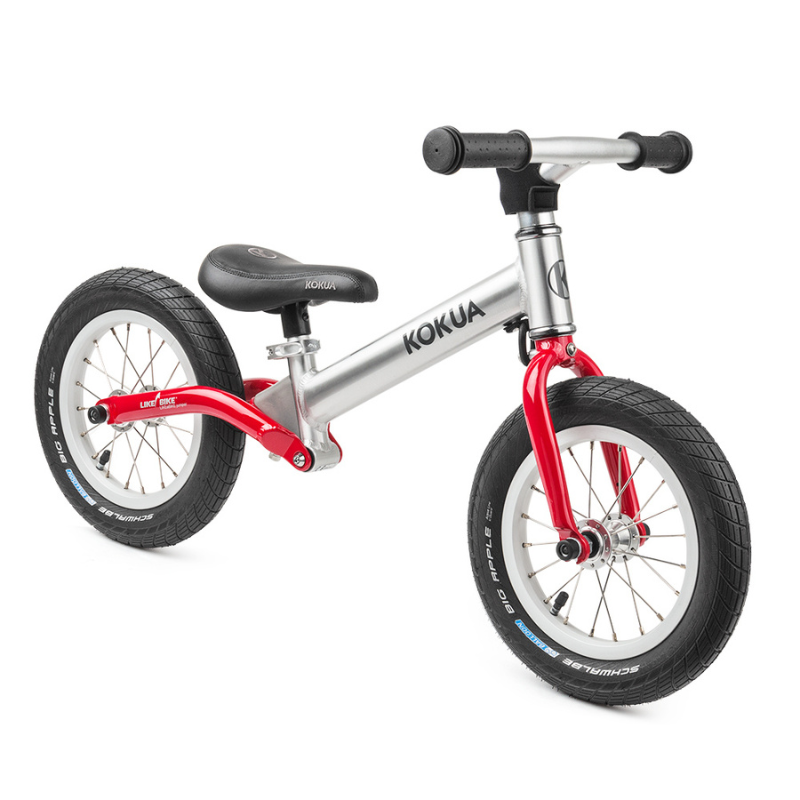 a silver and red KOKUA Jumper 12 balance bike on a white background